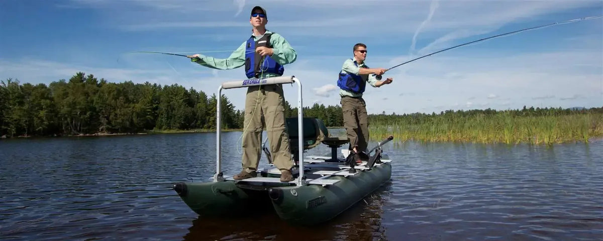 Two men fishing from a dark hunter green Sea Eagle 375fc FoldCat inflatable pontoon boat on a lake.