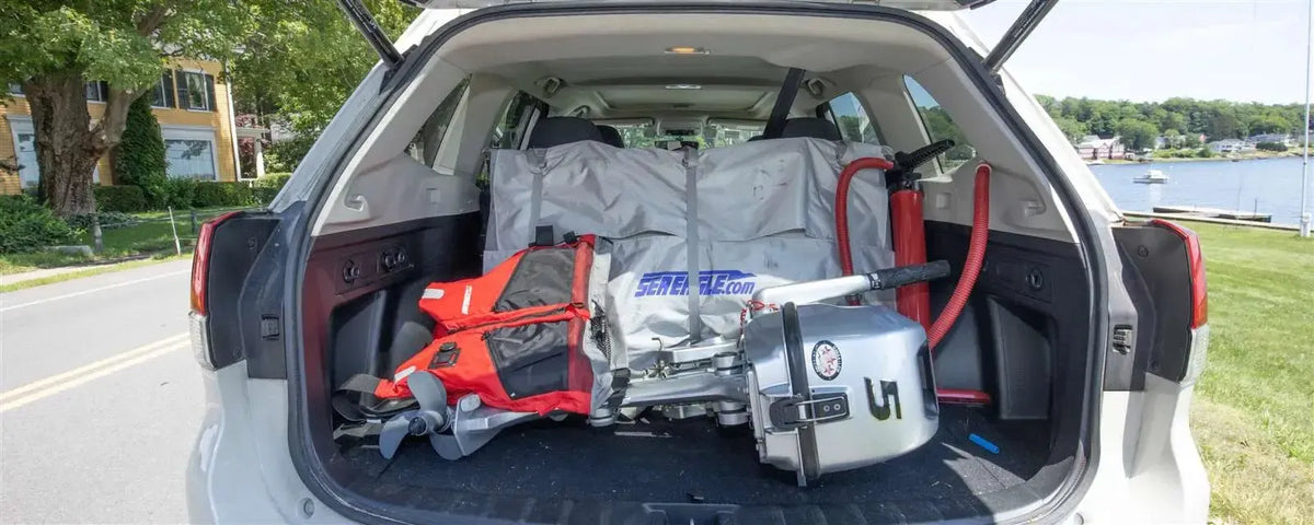 Sea Eagle 437ps PaddleSki inflatable boat, motor, and life vest packed in a car trunk.