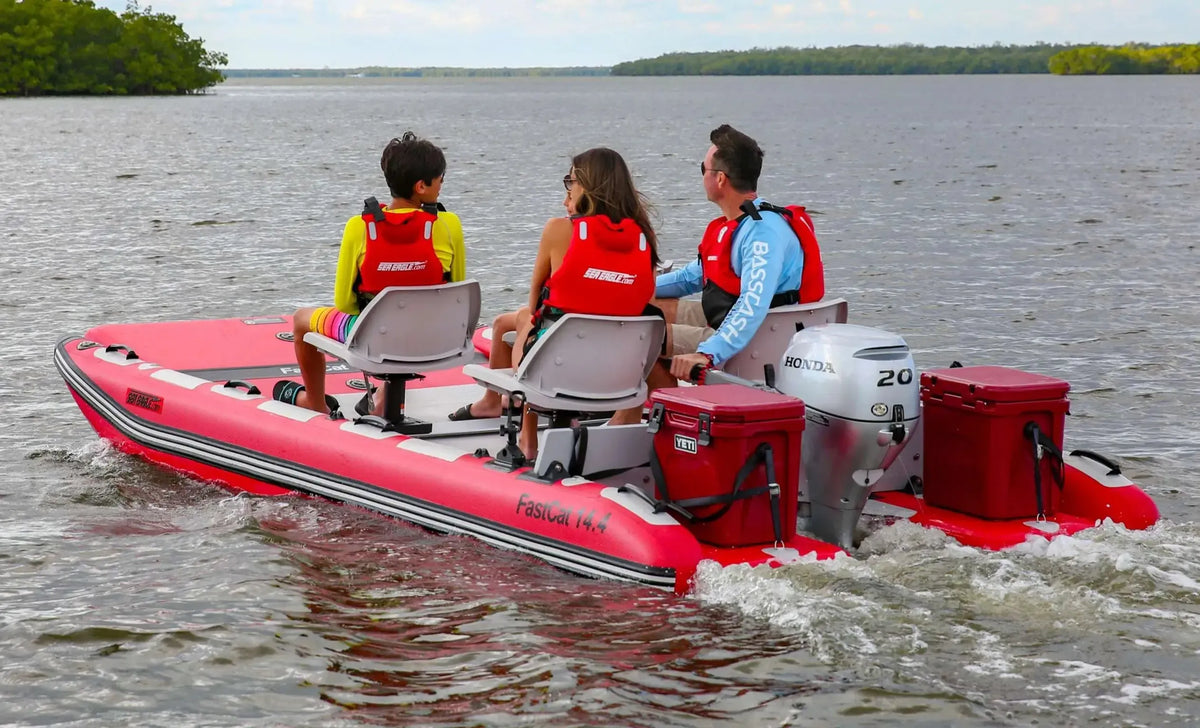 Red Sea Eagle FastCat14 inflatable catamaran with three people, an outboard motor, and two red coolers on the water.