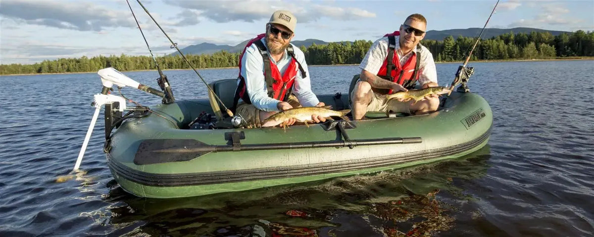 Two men in a hunter green Sea Eagle Stealth Stalker 10 inflatable fishing boat holding their catch.