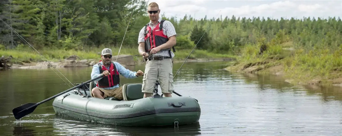 Two men fishing from a green Sea Eagle Stealth Stalker 10 inflatable boat on a calm river.