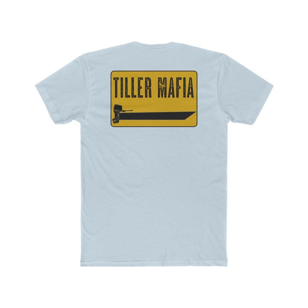 A light blue heather crewneck t-shirt shown from the back, featuring a yellow rectangular graphic with the text 'TILLER MAFIA' in black and a black tractor graphic.