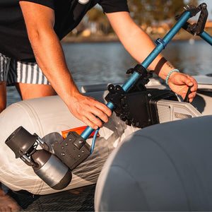 Person adjusting a device on a boat with water in the background