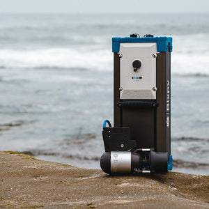 Portable water filtration system on a concrete surface with a water body in the background
