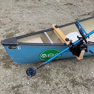 Blue kayak with a wooden paddle attached on a concrete surface