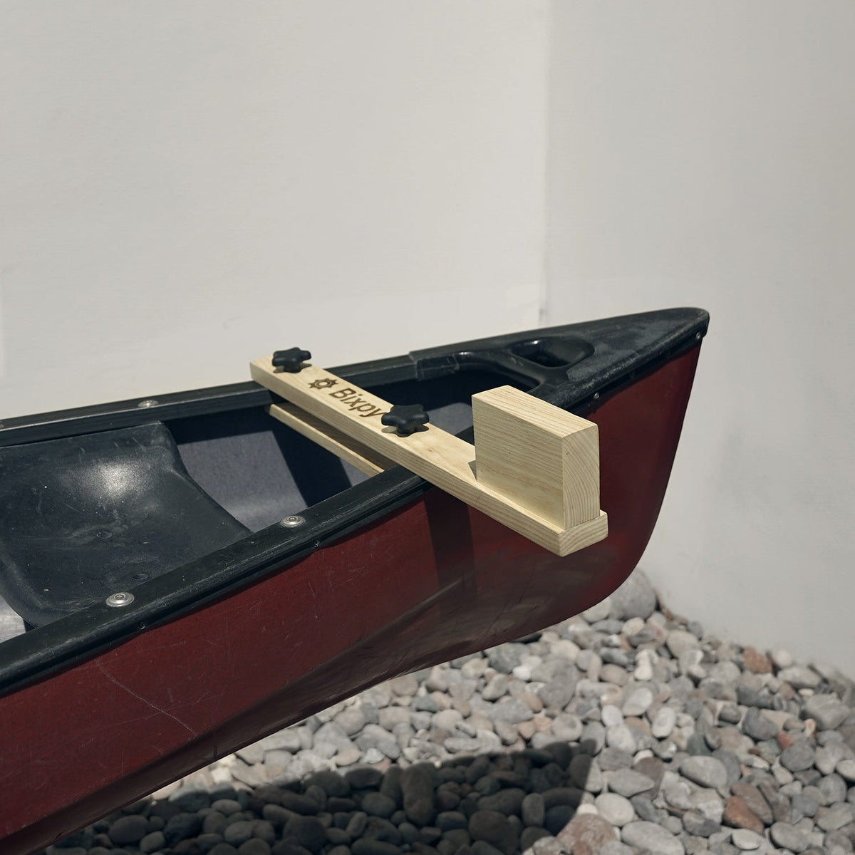 Model canoe with a wooden oar on a white background
