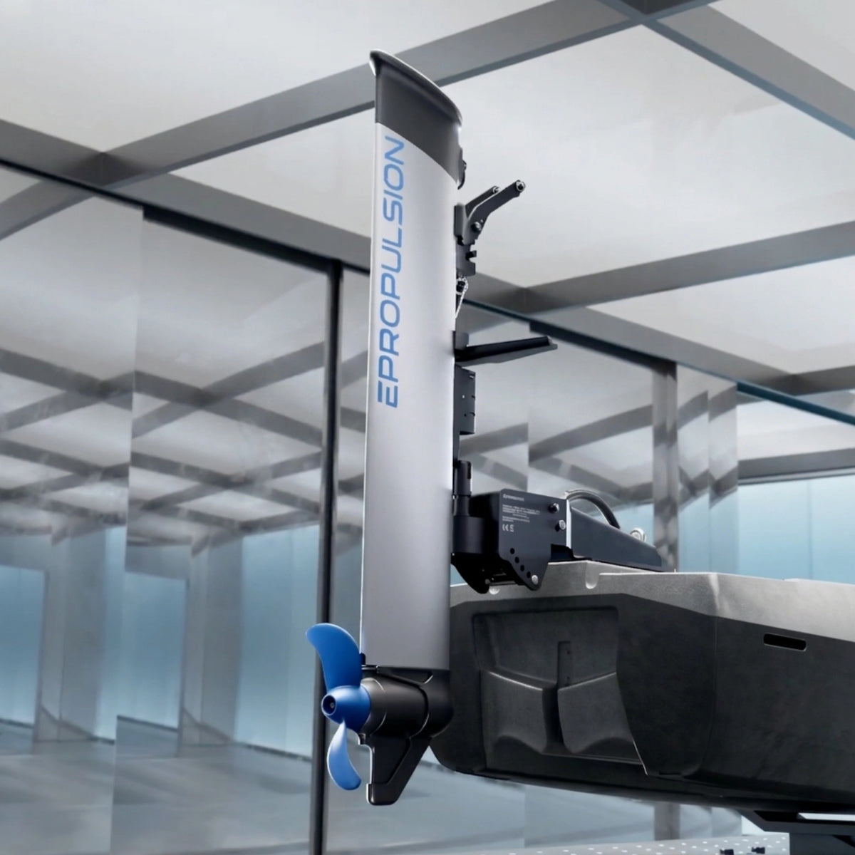 A close-up of an ePropulsion kLite 7500 electric boat motor and propeller assembly mounted on a hull, with the vertical shaft labeled EPROPULSION. The product is shown in a modern indoor studio or showroom setting with glass walls and ceiling panels.