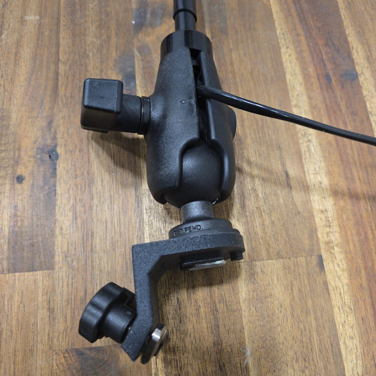 Assembled 45° T-Bolt Mount Package on a wooden surface, showing the angled track bracket with tightening knob, ball-and-socket clamp arm, and attached LED light pole with wiring.