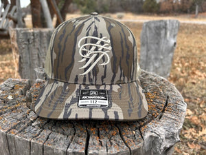 Camouflage cap with a logo on a wooden stump outdoors