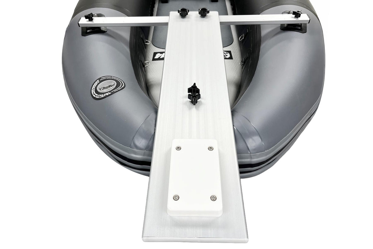 A white aluminum bow ramp and step ladder attachment shown mounted on the front of a gray inflatable dinghy, photographed from a top-down angle against a white background.