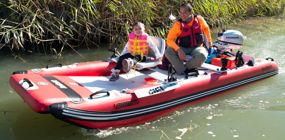 Red Sea Eagle FastCat12 inflatable catamaran with a man and child, Honda motor, on a river.