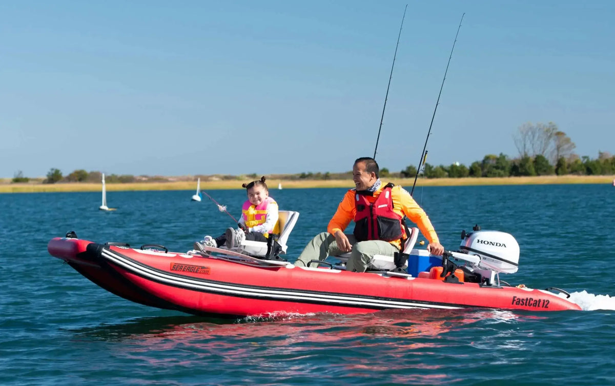 Red Sea Eagle FastCat12 inflatable catamaran with two people fishing on calm blue water.