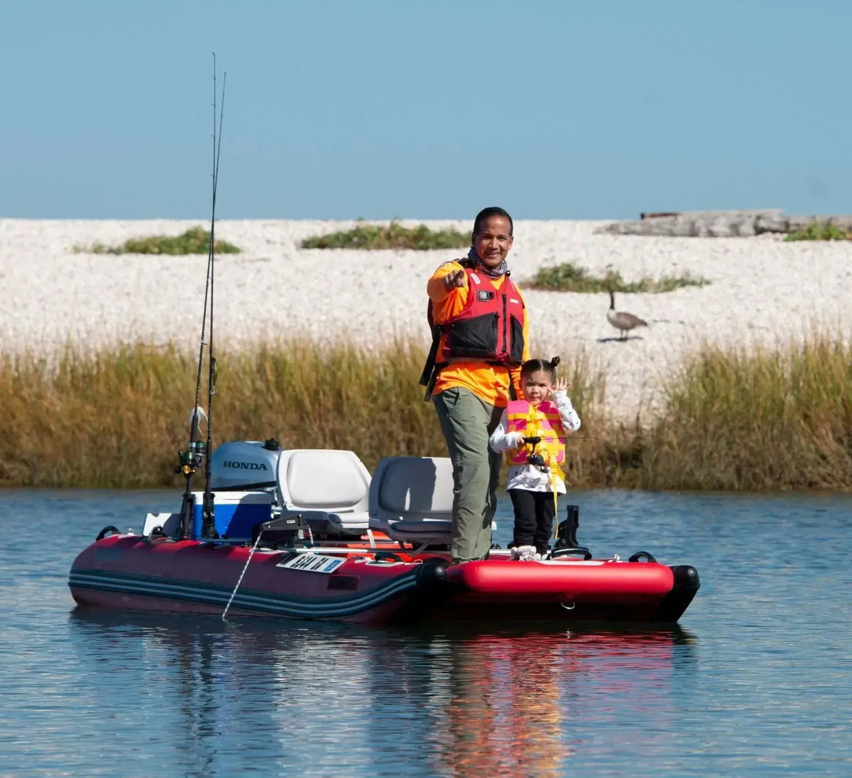Red Sea Eagle FastCat12 inflatable catamaran with two people fishing, featuring a Honda motor and fishing rods.