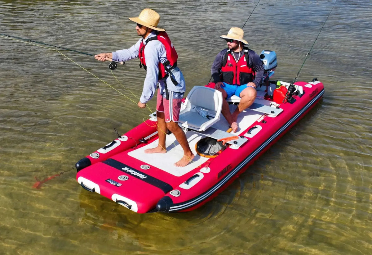 Two men fishing from a red Sea Eagle FastCat12 inflatable catamaran with an outboard motor.