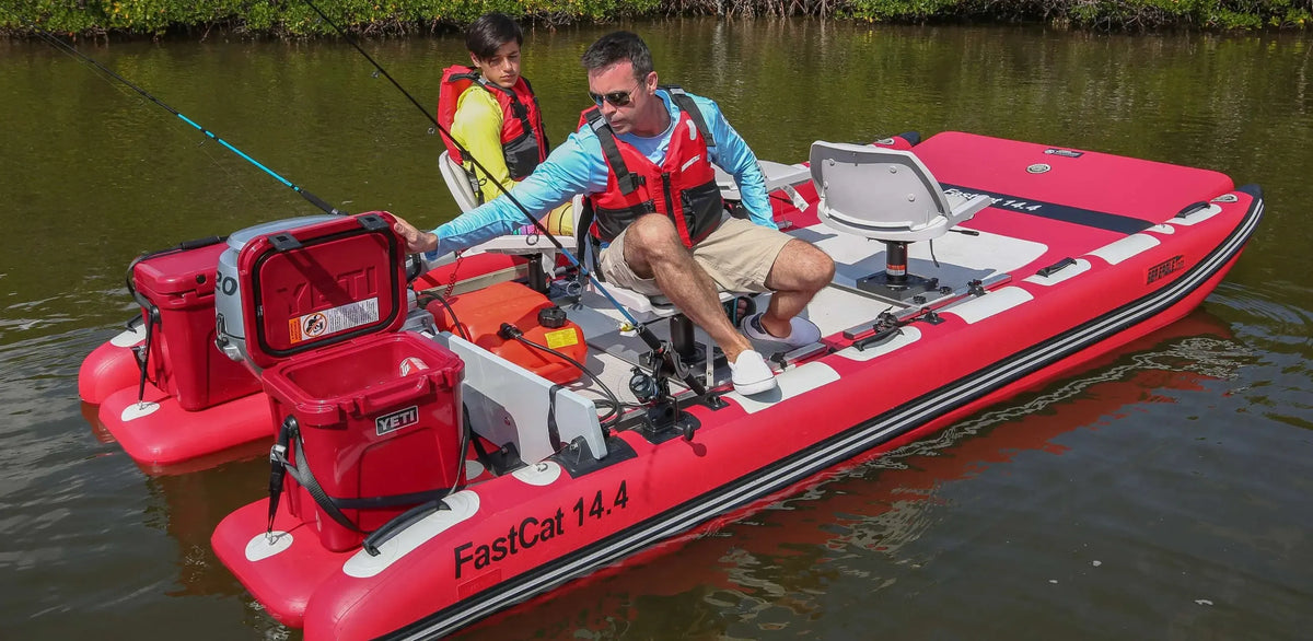 Red Sea Eagle FastCat 14.4 inflatable catamaran with two men fishing, featuring Yeti coolers and swivel seats.
