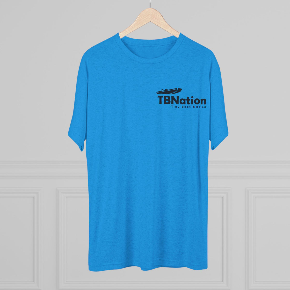 Blue t-shirt with 'TBNation' logo on a hanger against a gray background