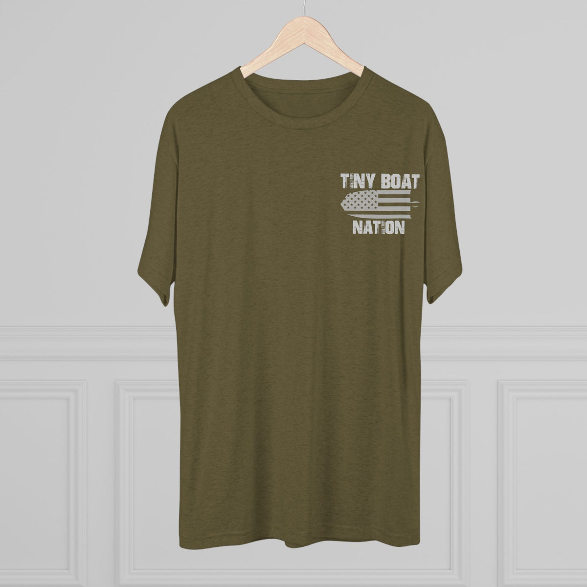 Olive green t-shirt with 'Tiny Boat Nation' text on a hanger against a gray background