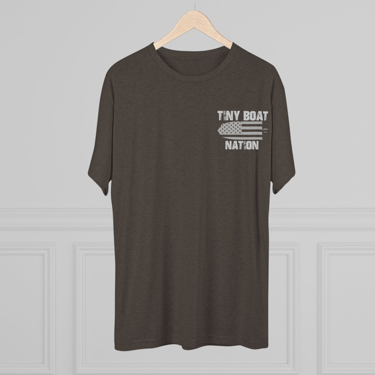 Brown t-shirt with 'Tiny Boat Nation' text on a hanger against a gray background