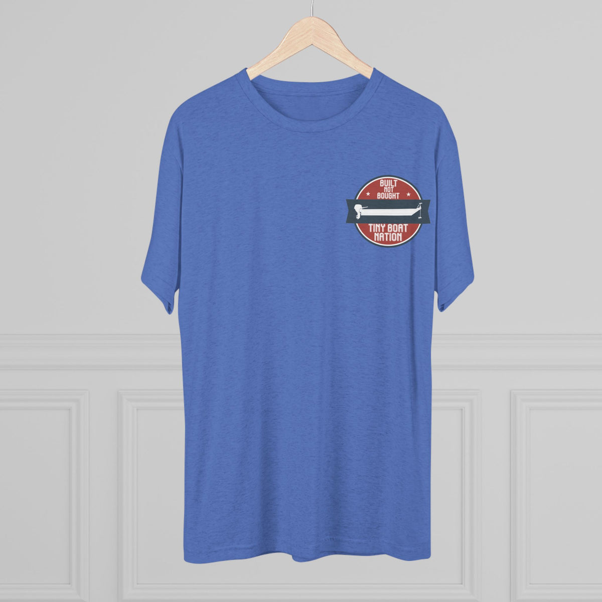 Blue t-shirt with a graphic design on a hanger against a gray background