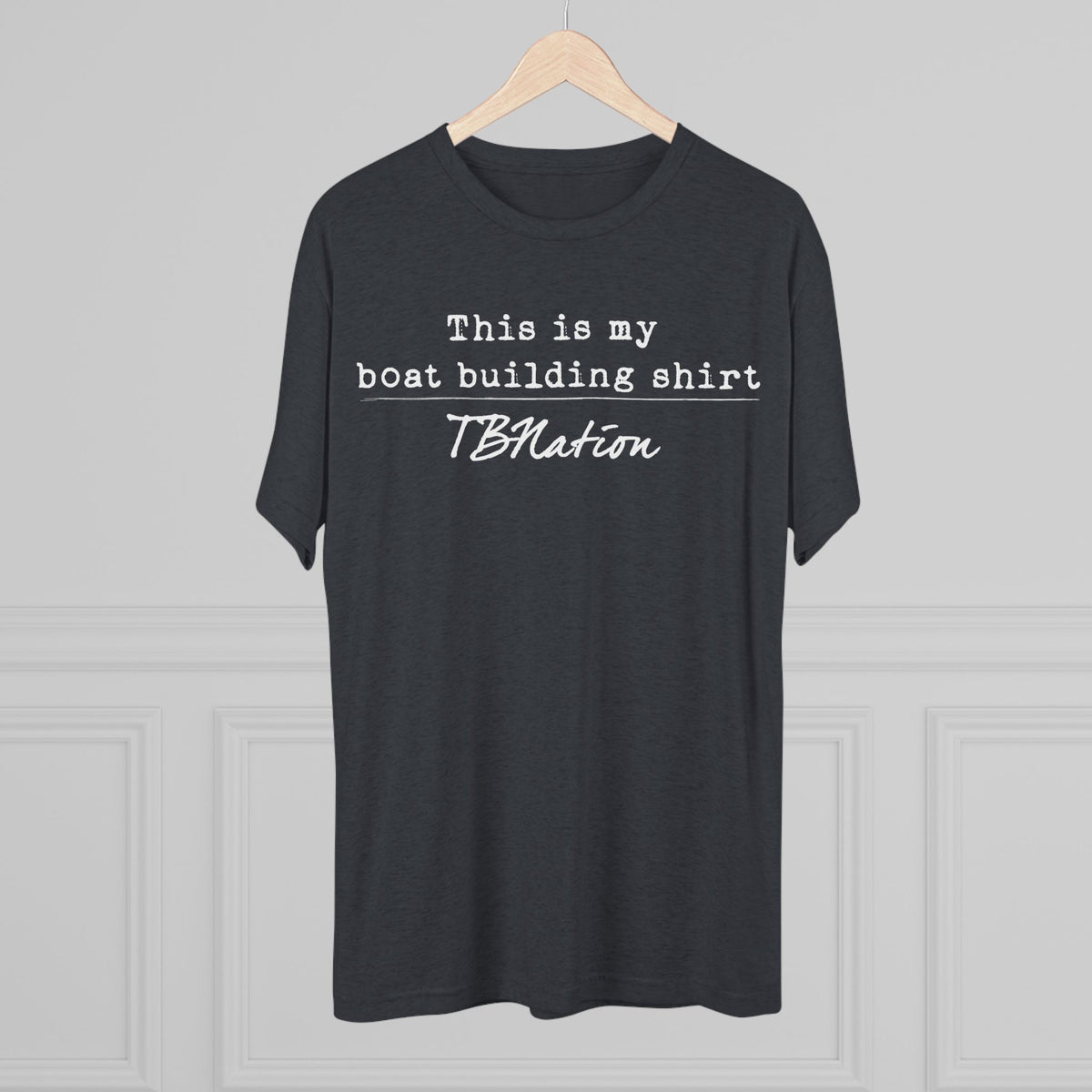 Black t-shirt with text on a hanger against a gray background
