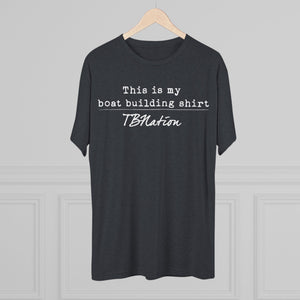 Black t-shirt with text on a hanger against a gray background