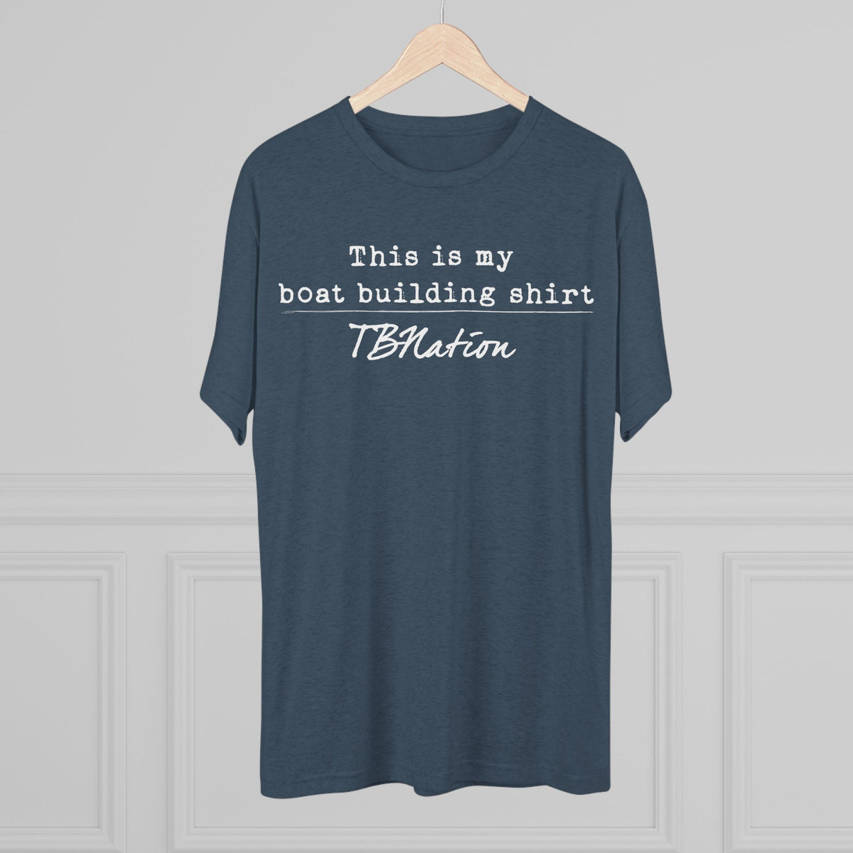 Blue t-shirt with text on a hanger against a gray background