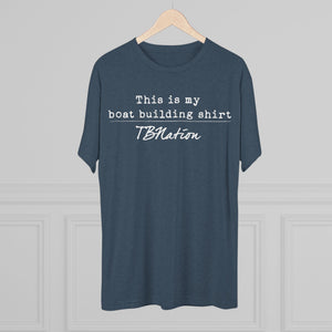 Blue t-shirt with text on a hanger against a gray background