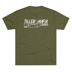 An olive green short-sleeve t-shirt with a white graphic print on the chest reading 'TILLER MAFIA' and 'THE JON YACHT' above a revolver illustration, shown on a plain white background.