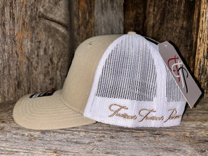 Beige and white baseball caps with a brand tag on a wooden surface