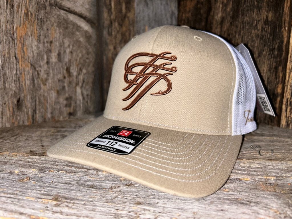 Beige cap with brown logo on a wooden surface
