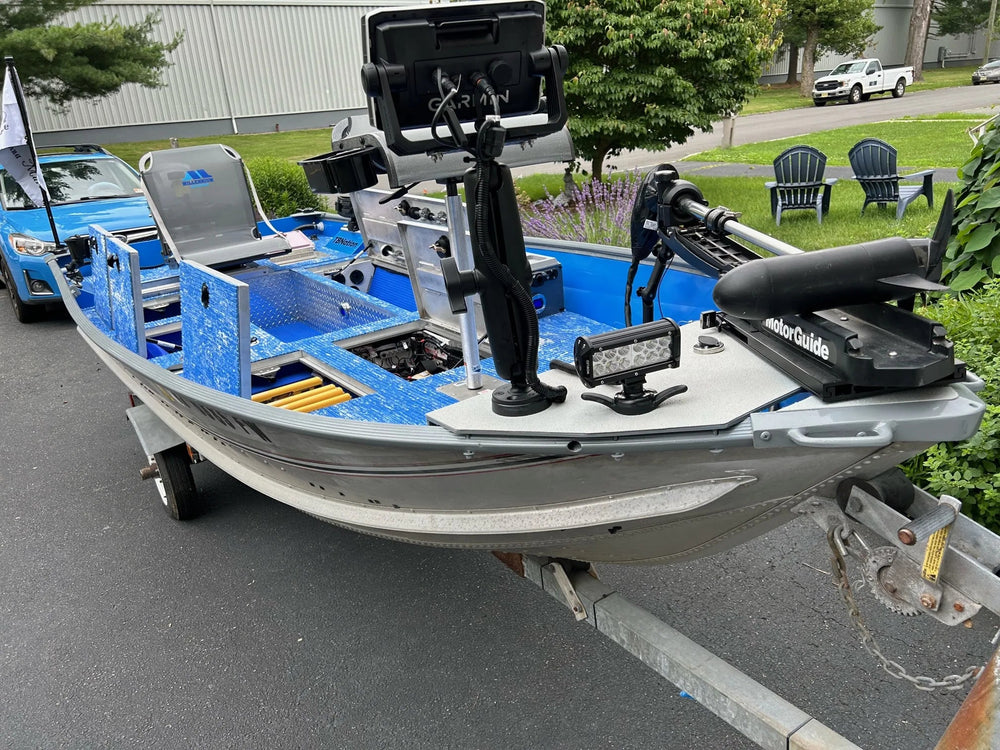 Boat casting deck with camo EVA foam traction pads and open hatch storage.