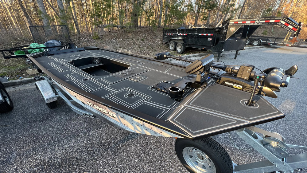 DIY Jon boat conversion with green woodland camo EVA foam floor padding in a garage.