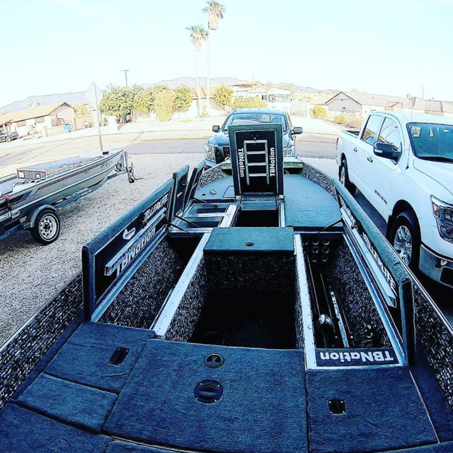 Dark gray cut pile marine carpet installed in a boat, showcasing storage compartments and a seamless finish.