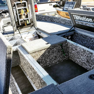 Gray 20 oz marine-grade premium boat carpet installed in a boat, showing textured cut pile and storage compartments.
