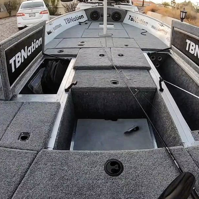 Gray 20 oz. premium cut pile marine carpet installed on a boat deck, showing storage compartments.