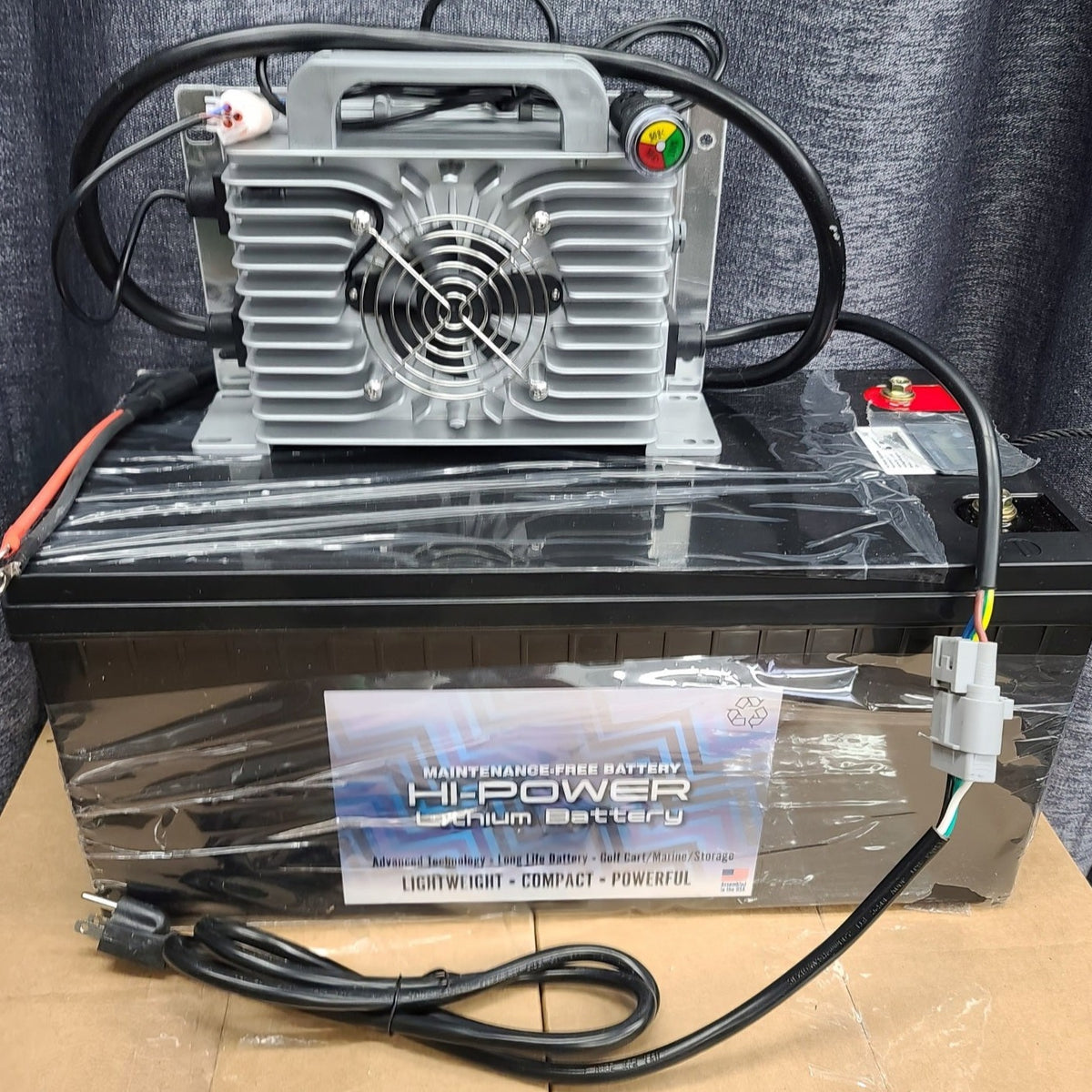 Black Hi-Power 48V lithium battery pack with a silver charger, fan, and cables.