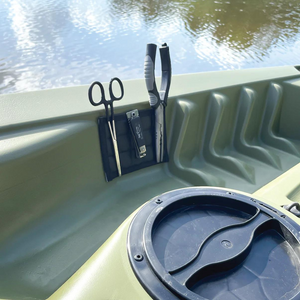 Black Magnalure Pad with scissors and pliers attached, mounted on the olive green interior of a kayak.