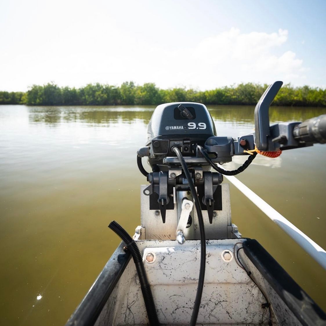 Silver electric OnTheFly Jackplate mounted on a boat with a black Yamaha 9.9hp outboard motor.