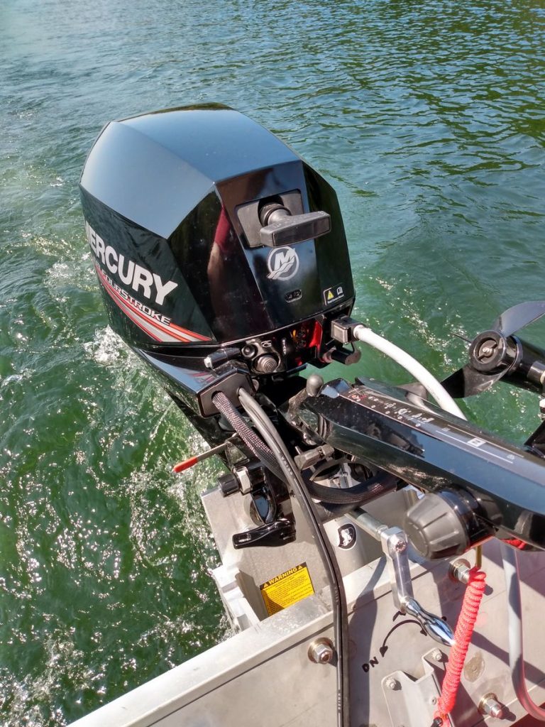 Black Mercury outboard motor attached to a silver OnTheFly Electric Jackplate on a boat.