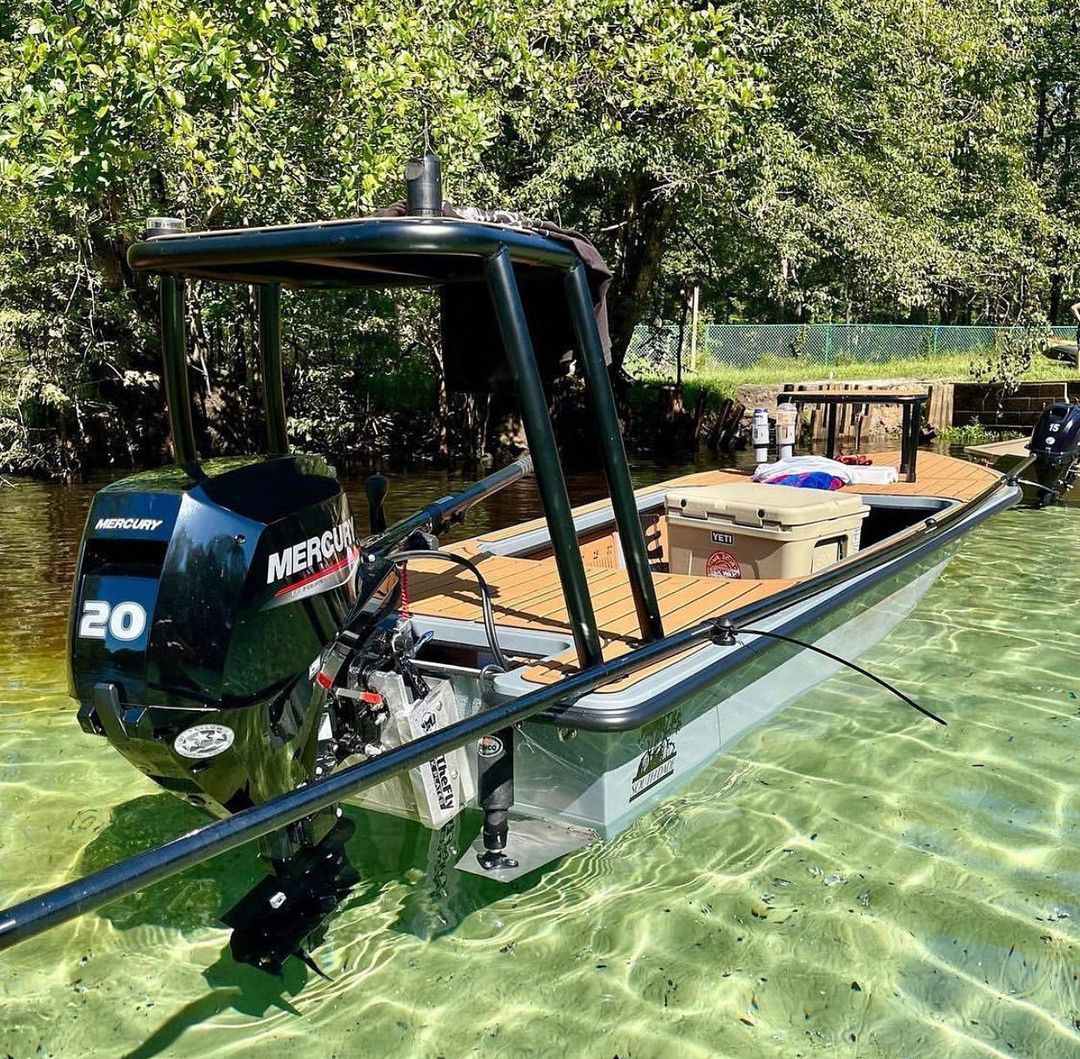 Gray boat with a black Mercury 20HP outboard, black jackplate, and tan deck in clear water.