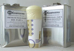 Two silver US Composites cans of 2 Lb density urethane pour foam, with a paper cup of expanded foam in the center.