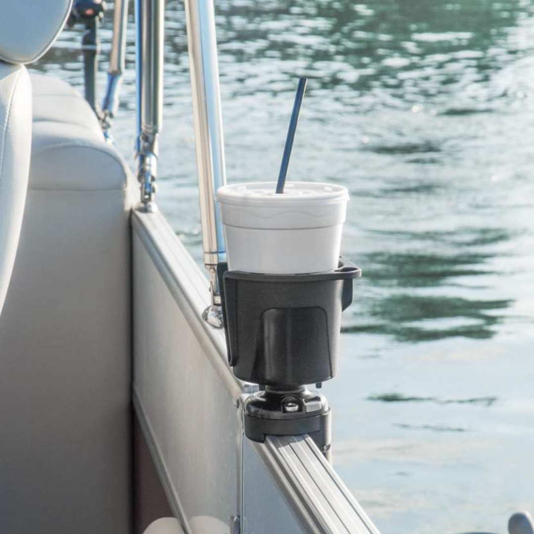 Black Railblaza DrinkHold mounted on a boat railing, holding a white foam cup with a straw.