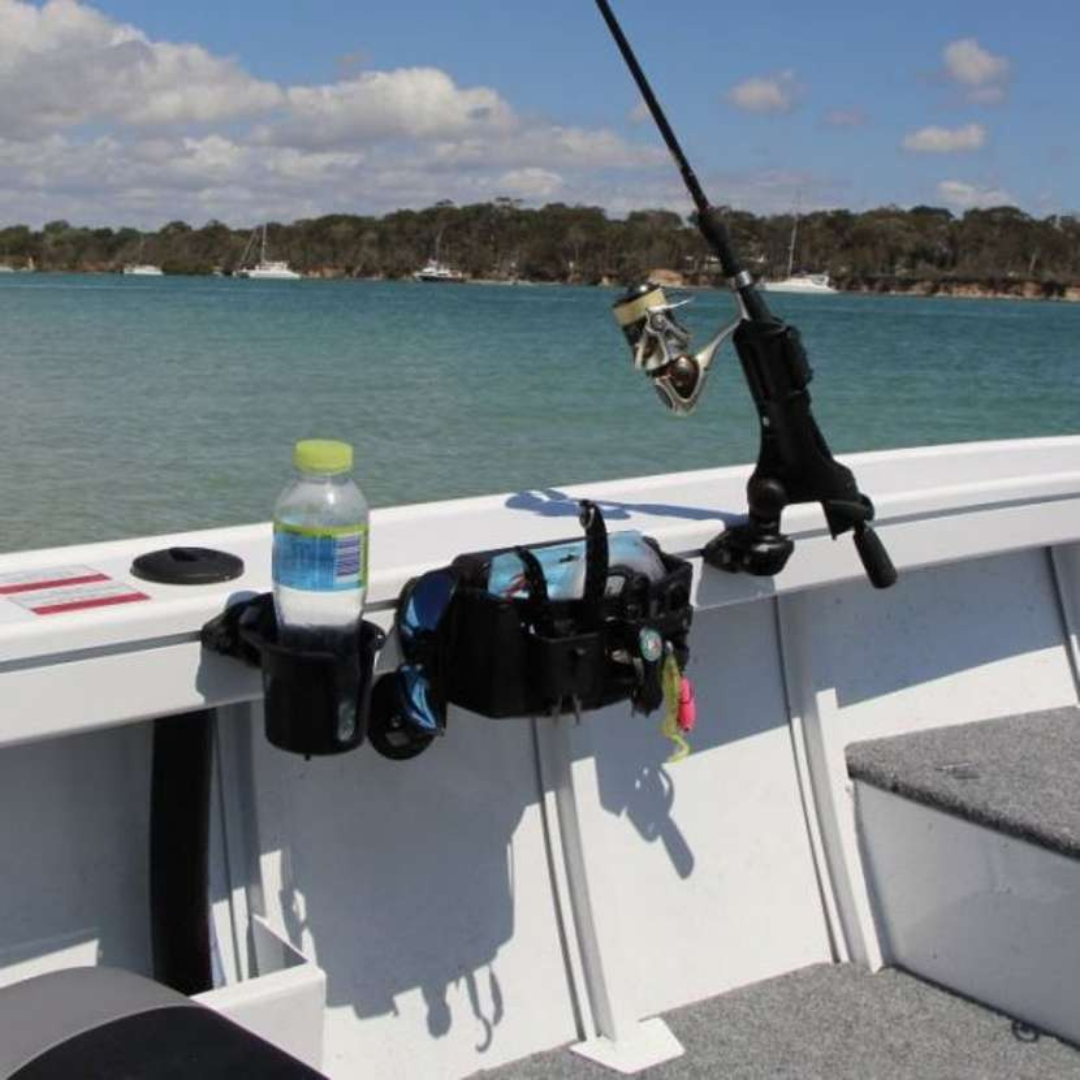 Black Railblaza Track Mount Tackle Caddy with a drink holder and fishing rod attached to a white boat gunnel.